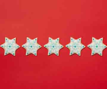 Five star-shaped Christmas cookies, festively decorated