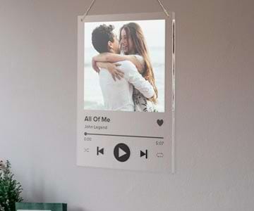 Acrylic music player with couple photo hanging on a wall.
