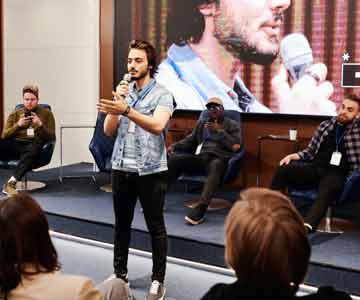 A speaker holding a microphone, giving a speech.