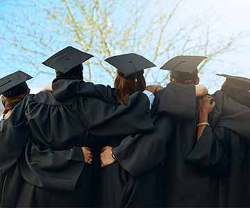 High School Graduates Wrapping Arms Around Each Other
