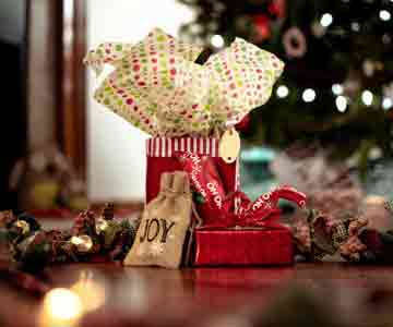 Gifts tucked under a glowing Christmas tree.