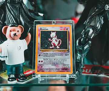 Mewtwo Pokémon card in a display case, surrounded by collectible figurines for a striking showcase.