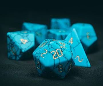 A collection of blue quartz dice on a table.