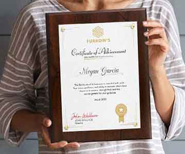 Certificate Display Kit Held By Woman In Front Of Blue Wall.