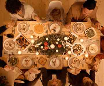 Top view of family gathered around table for Thanksgiving dinner.