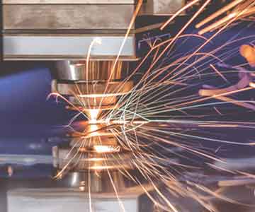 Laser engraving on metal with bright sparks flying.