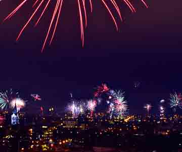 New Year’s Eve fireworks over a city skyline by the lakeside.