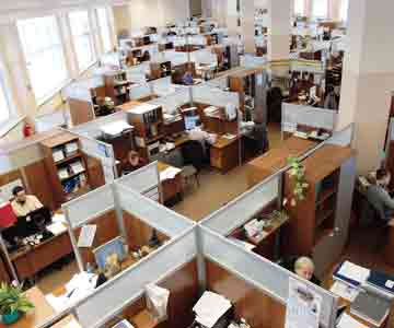 A large office filled with cubicles and busy workers.