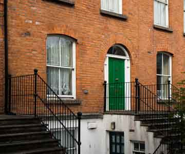 Georgian-style house with a front yard and entry stairs.