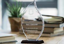 Engraved Faceted Acrylic Flame Award Trophy On Table With Books.