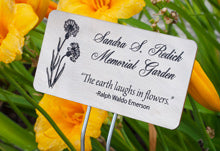 Engraved Titanium Memorial Garden Sign Near Yellow Flowers.
