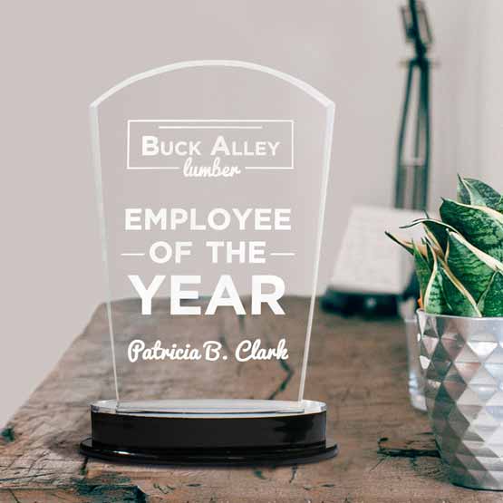 Custom Acrylic Arch Award For Employee Of The Year With Silver Mirror Base And Logo And Name On Wood Desk With Lamp And Plant