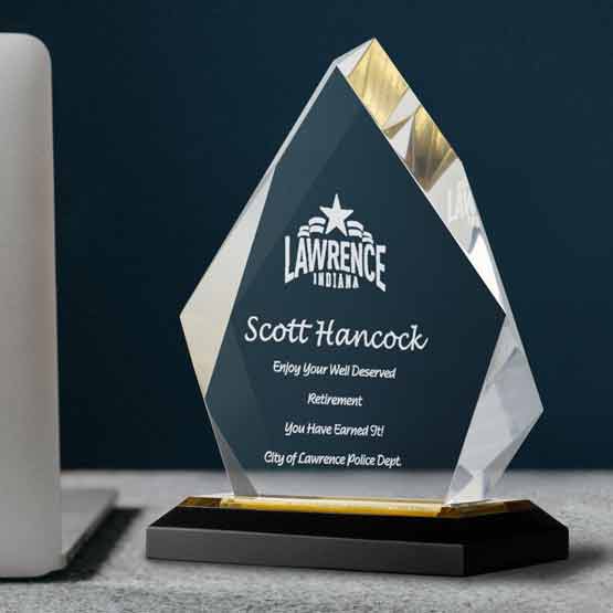 Custom Diamond Shaped Acrylic Award For Retirement With Logo And Name And Gold Mirror Base On Gray Work Desk With Laptop