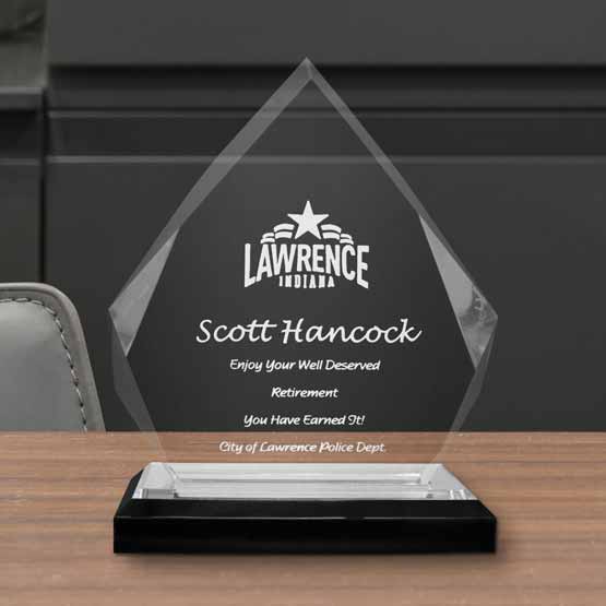 Custom Diamond Shaped Acrylic Award For Retirement With City Logo And Name And Silver Mirror Base On A Wood Work Desk