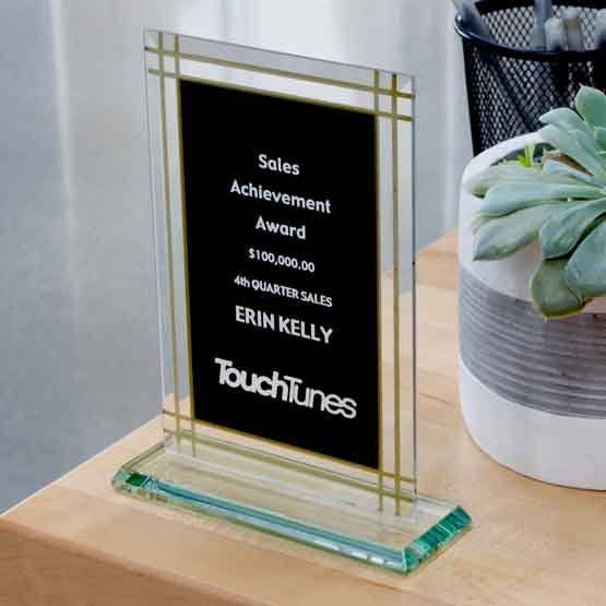 Custom Black And Gold Glass Award For Sales Achievement With Jade Glass Base On Wood Work Desk With Potted Plant