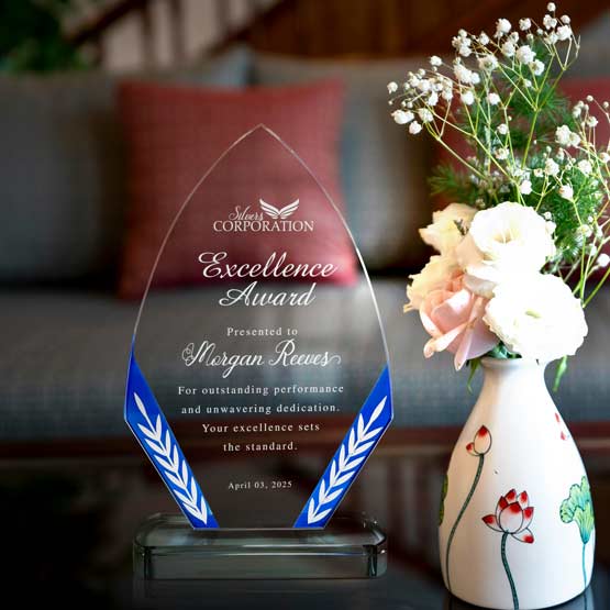 Custom Diamond Shaped Glass Award With Blue Edge And Glass Base On Living Room Coffee Table Near Vase Of Flowers