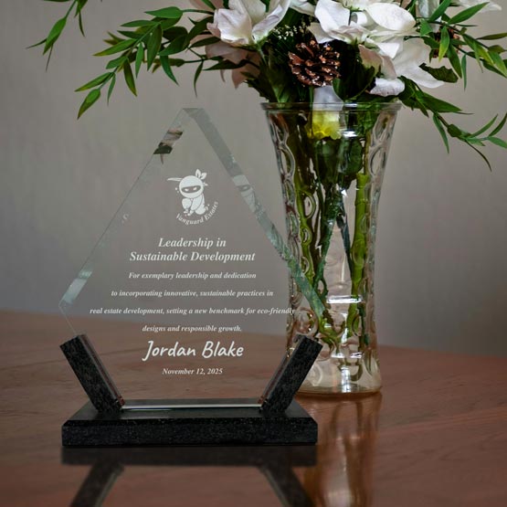 Custom Diamond Shaped Glass Award For Leadership With Black Marble Base On Wood Table With Flowers In A Glass Vase