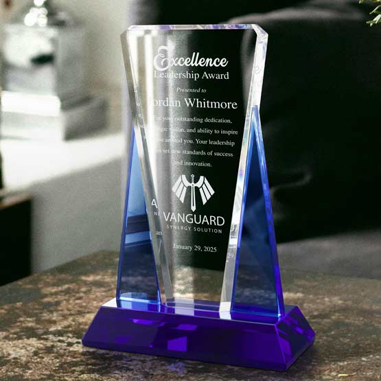 Custom Blue And Clear Glass Award For Excellence With Wedge Shape And Blue Base On Marble Kitchen Counter