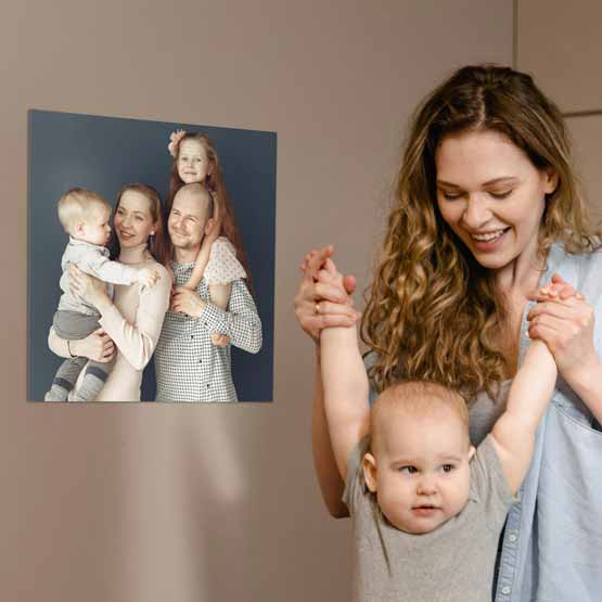 Woman With Baby In Living Room Near A Custom Aluminum Metal Photo Print With Full Color Family Photo Mounted On Wall