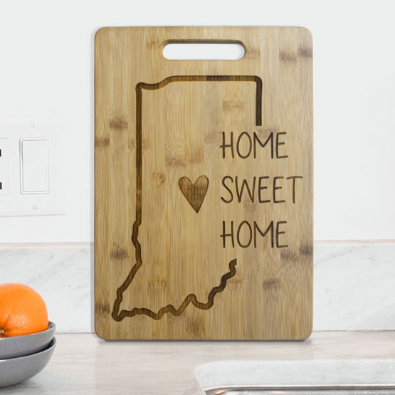Custom Bamboo Cutting Board Engraved With State Shape And Home Sweet Home Text On White Kitchen Table With Oranges
