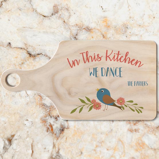 Custom Paddle Shaped Pine And Bamboo Cutting Board With Full Color Bird Artwork And Fun Kitchen Text On A Marble Counter