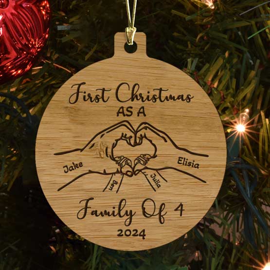Custom Circle Bamboo Ornament With First Christmas Text And Hands Making Heart Art And Family Names Hanging On Christmas Tree