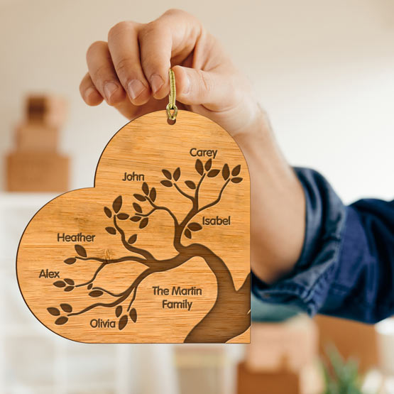 Woman Hand Holding Custom Heart Shaped Bamboo Ornament Engraved With Family Tree Artwork And Family Names Via Gold String