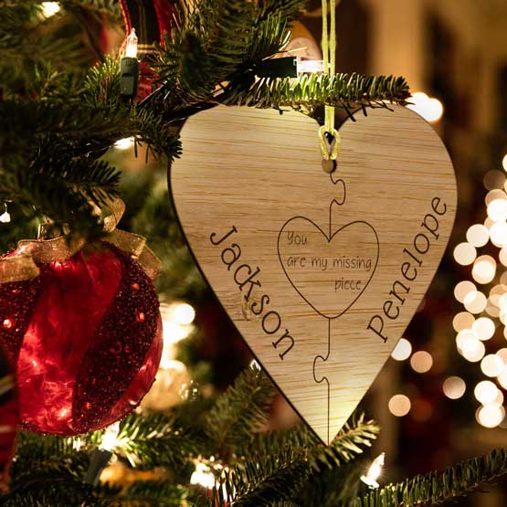 Custom Heart Bamboo Ornament Engraved With Puzzle Piece Artwork And Couple Names Hanging On Christmas Tree Via Gold String