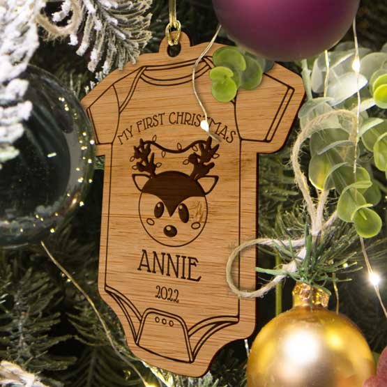Custom Onesie Shaped Bamboo Ornament With My First Christmas Text And Cute Reindeer Art And Date Hanging On Christmas Tree