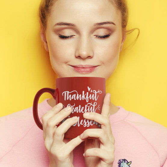 Woman Holding And Sniffing A Custom Orange Coffee Mug Engraved With Cursive Thankful Grateful And Blessed Text