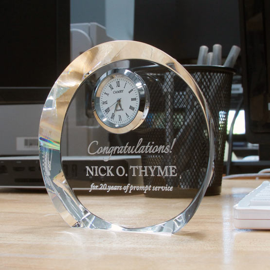 Custom Circle Glass Clock Engraved With Years Of Service Appreciation Message Freestanding On Busy Office Desk