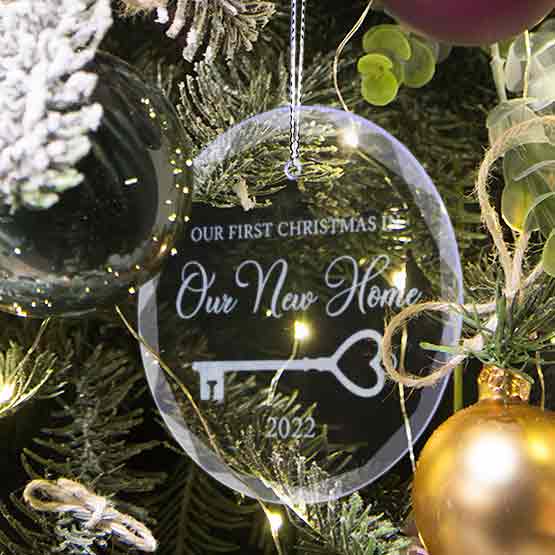 Custom Circle Glass Ornament Engraved With First Christmas In Our New Home Text And Key Art And Date On A Christmas Tree