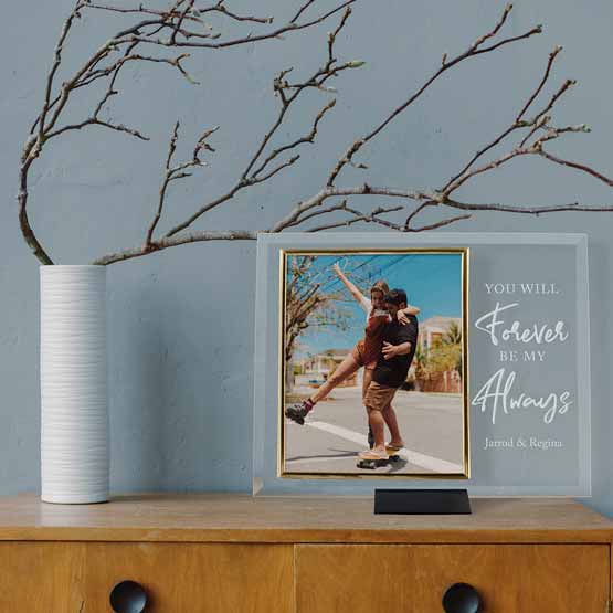 Custom Glass Picture Frame With Couple Photo And Engraved With Names And Romantic Message On Dresser With Plant In Vase