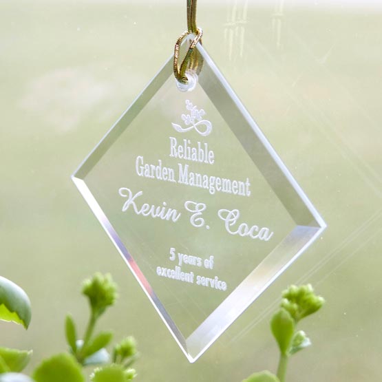 Diamond Shaped Glass Suncatcher Engraved With Logo And Years Of Service Appreciation Message Hanging By Window Above Plants