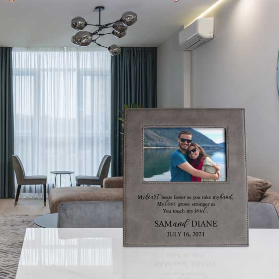 Custom Gray Faux Leather Picture Frame With Photo Of Couple On Vacation And Romantic Message On Table In Tidy Living Room