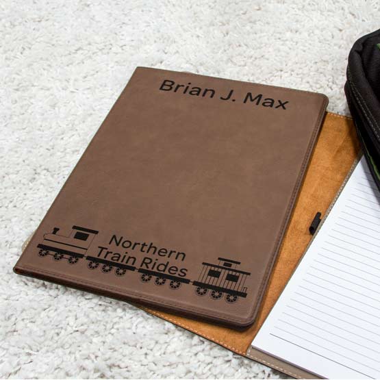 Dark Brown Faux Leather Notebook Engraved With Name And Northern Train Rides Logo On Carpet With Notepad And Laptop Case
