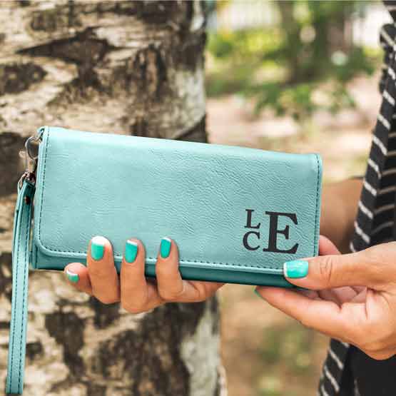 Woman Hands Outdoors Holding Custom Teal Faux Leather Trifold Wallet With Wrist Strap And Laser Engraved With Initials