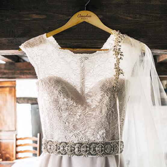 Wedding Dress Hanging Indoors On Custom Maple Wood Clothes Hanger With Metal Hook And Engraved With Name And Bride Text