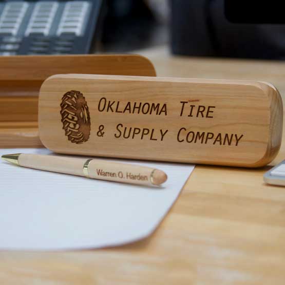 Closed Maple Wood Pen Case Engraved With Tire Company Name And Logo On Busy Office Desk With Matching Pen Engraved With Name