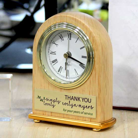 Red Alder Desk Clock With Portrait Arch Shape And Metal Trim And Gold Plate With Print Of Logo And Thank You Text On A Desk