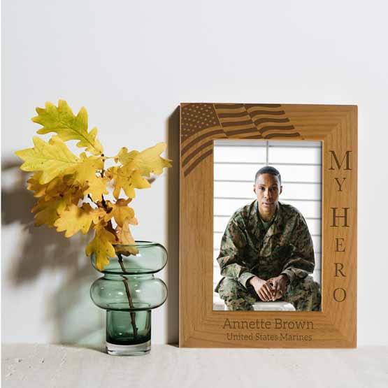 Red Alder Picture Frame With Soldier Photo And Engraved With American Flag And Soldier Details On White Shelf With Flowers