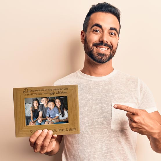 Man Holding And Pointing To Red Alder Picture Frame With Siblings Photo And Engraved With Names And Funny Message For Dad