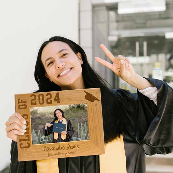 Student Holding Red Alder Picture Frame With Her Graduation Photo And Engraved With Class Of 2024 And Student Details