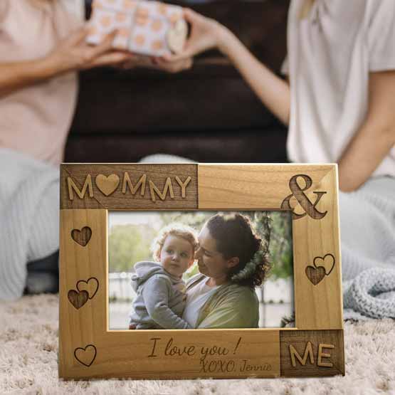 Mom And Child Exchanging Presents Behind Red Alder Picture Frame With Photo Of Mom And Baby And Engraved With Mommy And Me