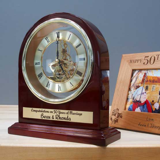 Rosewood Arch Desk Clock With Open Gears And Metal Plate Printed With Couple Names And Anniversary Message On Wood Shelf