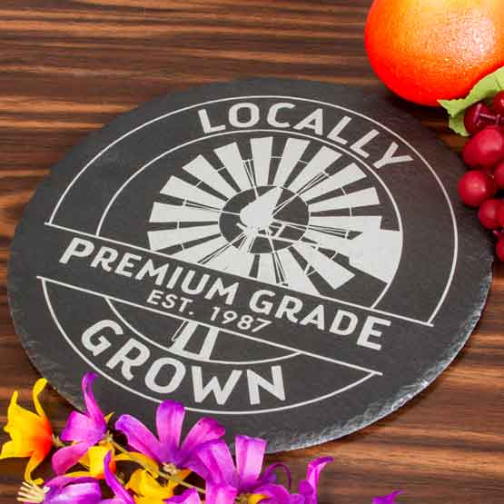 Custom Circle Slate Sign Printed With Locally Grown And Premium Grade And Weather Vane Artwork On Wood Table With Fruit