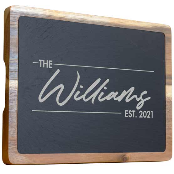 Rectangle Slate Sign Inside Cutting Board Style Acacia Board Printed With Family Name And Date Against White Background