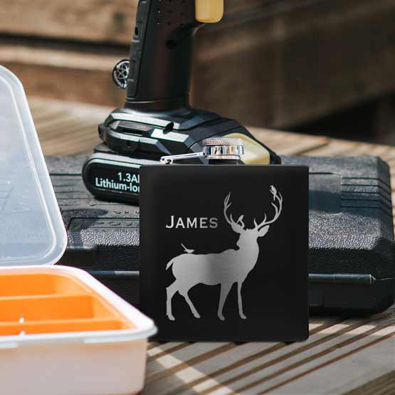 Black Powder Coated Stainless Steel Flask Laser Engraved With Elk Artwork And James On Wood Table With Power Tools