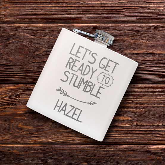 Custom White Powder Coated Stainless Steel Flask Engraved With Let’s Get Ready To Stumble And Hazel On A Wood Table