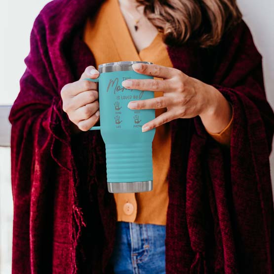 Robed Woman Holding Teal 20 Ounce Tumbler With Handle And Engraved With This Mommy Is Loved By And Kids Names And Handprints